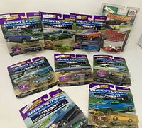 Front view of nine sealed Johnny Lightning diecast cars in packaging