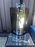 Front view of Krups BeerTender showing chrome tap with Heineken badge and drip tray