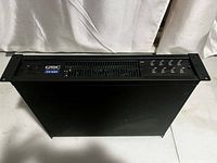 Front view showing QSC logo, power switch, ventilation grille and control LEDs