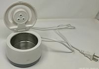 Ultrasonic cleaner open showing stainless basin and cord