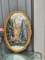 Front view of oval wall mirror held upright