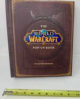 Front cover with title, author credit and measuring tape for scale