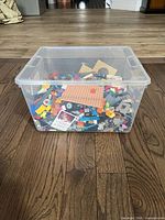 Front view of clear bin showing assortment of LEGO parts