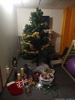 Full view of assembled 6.5 ft tree with gold tinsel, accessories on floor
