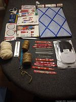Full lot view showing yarn, twine, patterns, memo board, vinyl liner, pins, scissors, hooks and needles