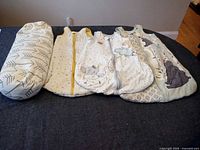 Group shot of nursing pillow and three sleep sacks laid flat