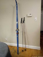 Full view of skis standing and poles leaning