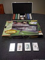 Open poker chip case with chips, dice, cards and Championship Casino box