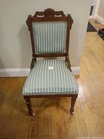 Front view of wooden upholstered chair with casters
