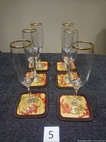 Six gold-rim flutes on matching coasters, front view