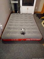 Full view of inflated grey top red side queen mattress