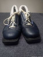 Front view of Karhu blue cross-country ski boots showing laces and toe plates