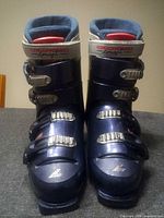 Front view showing both blue Lange ski boots with buckles and branding