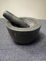 Mortar with pestle resting inside showing overall appearance and color