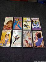 Front covers of all eight VHS tapes laid out