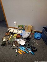 All items laid out including cookware, tools, bowls, plates, cords and accessories