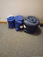 Three rolled sleeping bags side by side