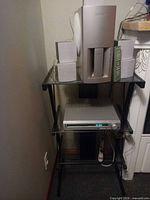 Full setup showing subwoofer, four speakers, DVD receiver on glass stand