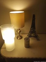 Front view of both lamps illuminated and Eiffel Tower figurine on table
