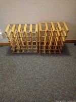 Two wood and metal wine rack units side by side