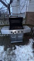 Grill with lid open showing grates, control panel and cabinet