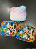 Front view of three lunch boxes showing graphics and patterns