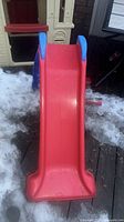 Front view of red slide surface and blue handrails