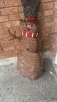 Front view of wicker snowman showing body, hat, scarf, arms, power cord