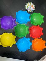 Nine assorted coloured frog stepping stones laid out with colour spinner