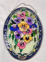 Full view of oval floral stained glass panel with chain