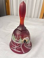 Front view of red cranberry glass bell with painted winter scene