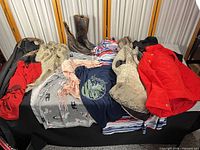 Overall view of lot with clothing pieces and boots displayed on table