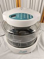 Full assembled oven showing lid, keypad, glass bowl and base