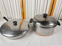 Frying pan and stock pot with lids side by side