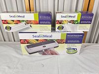 Boxes of Seal-a-Meal vacuum sealer, bag set, and roll set displayed together