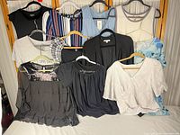 Overview of all twelve tops on hangers