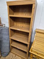 Oak-finish tall bookcase front view showing shelf arrangement