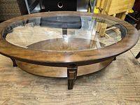 Angled view showing full coffee table with glass top and wood frame