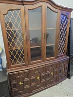 Full front view of china cabinet showing upper glass doors with lattice and lower paneled storage doors