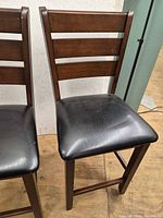 Front view of both stools showing ladder backs and seat material