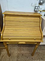 Front view closed showing tambour cover and turned legs