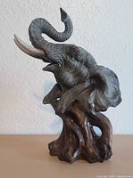 Elephant head resin sculpture on tree-root base