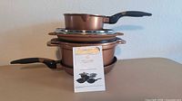 Stacked cookware pieces showing saucepan, steamer insert, pot and collapsible basket