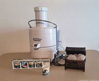 Overall view of juicer, cups in sleeve, separate cup, trinket chest open with crystals