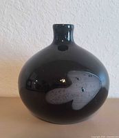 Front view of glossy black spherical vase with grey abstract motif