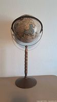 Full view of globe on pedestal stand