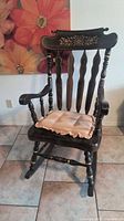 Full view of dark wood rocking chair with cushion