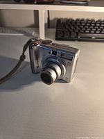 Front angled view showing lens, body and wrist strap