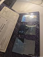 Open folio showing three hologram plates and certificate
