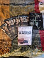Overview of Supernatural Season 4 set with four disc cases, slipcase, and sealed The Substance DVD